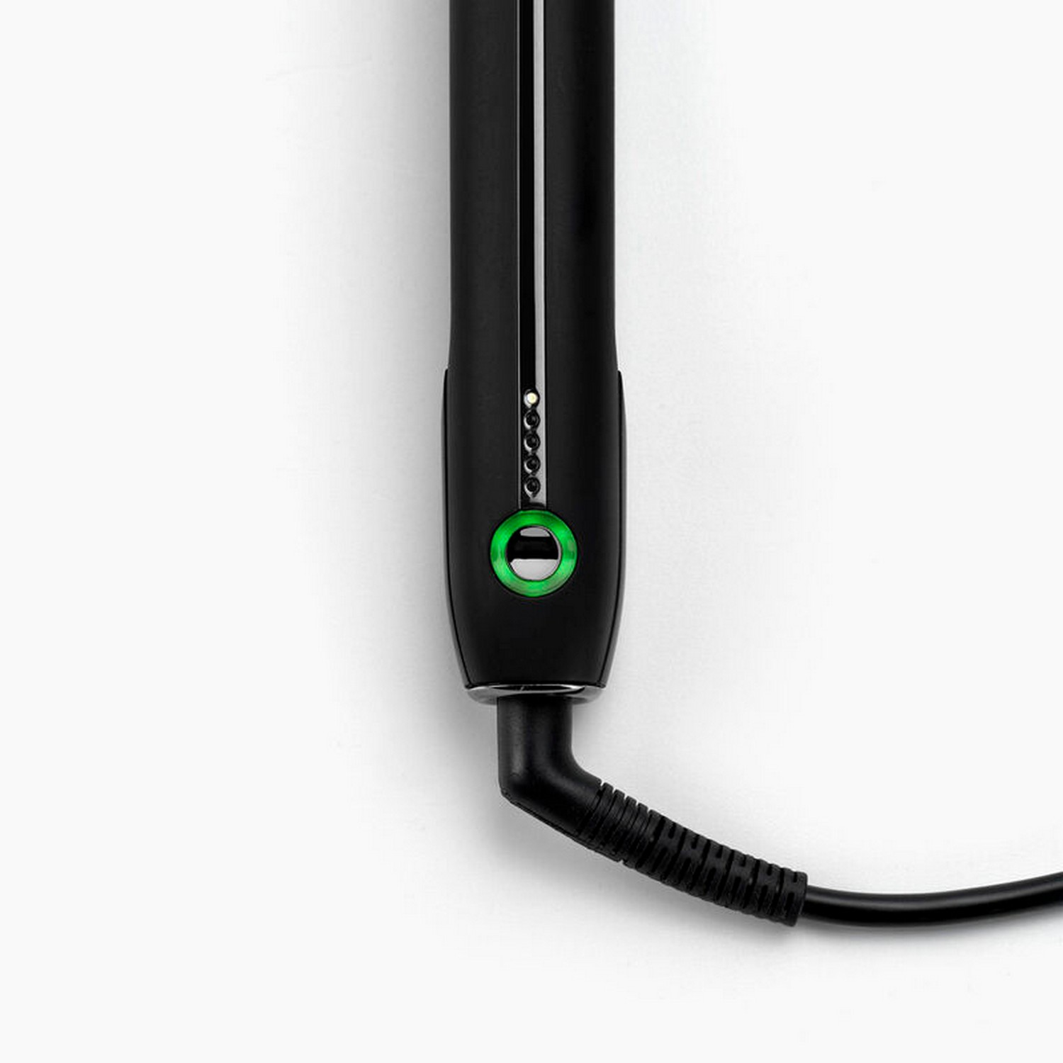 Black hair straightener. Green power button. Isolated on white background. Close-up view.