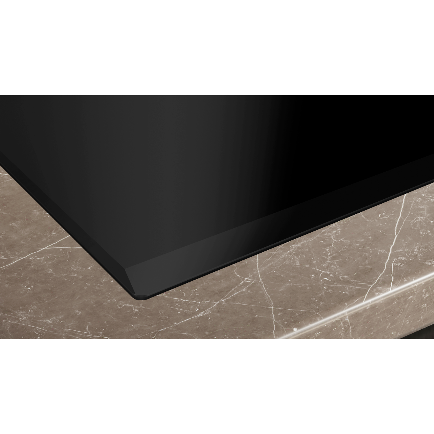 Close up of black induction cooktop with marble countertop.