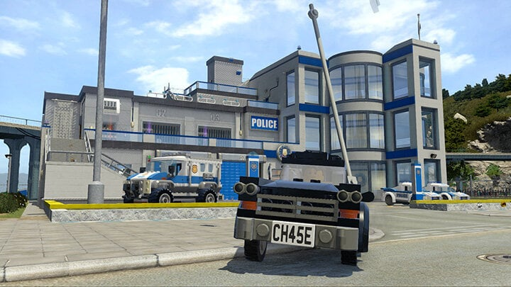 Posterunek policji Lego z radiowozem i ciężarówką przed budynkiem.