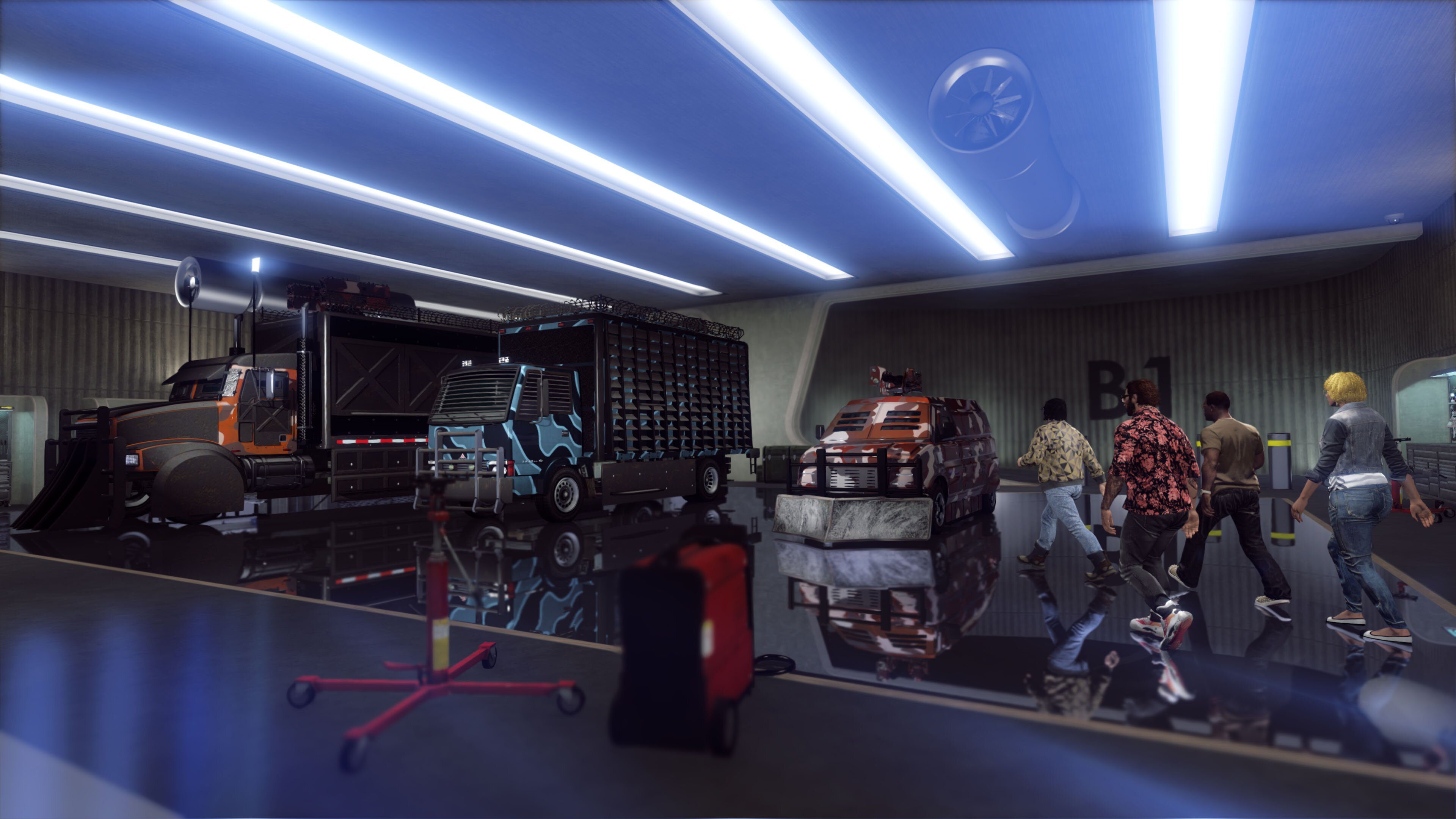 Garaż z pojazdami i ludźmi. Widoczny czerwony podnośnik i kilka pojazdów.