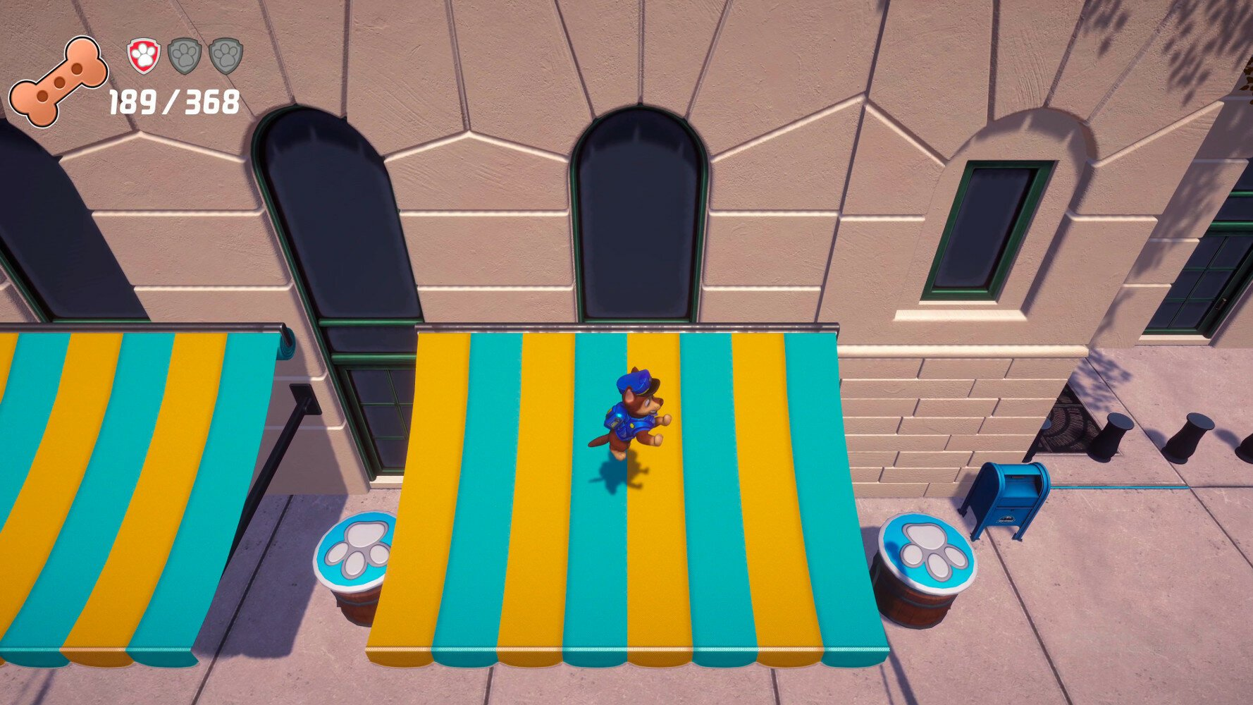 Postać z Psiego Patrolu biegnie po pasiastym markizie. W tle budynki i beczki z odciskami łap.