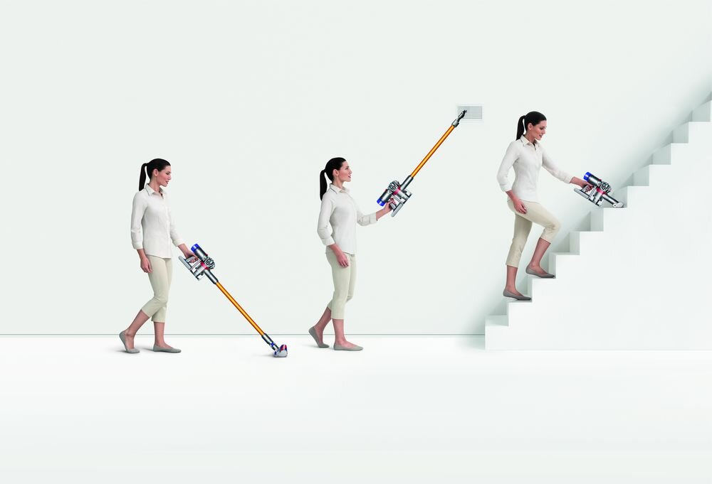 Kobieta używająca odkurzacza Dyson do sprzątania, wchodząca po schodach.