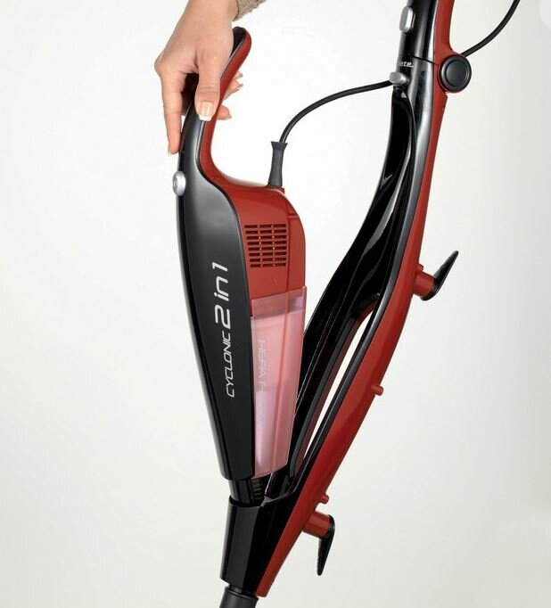 Czerwony i czarny odkurzacz Cyclone 2 w 1. Kobieta trzyma uchwyt.