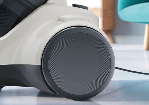 Zbliżenie koła odkurzacza z szarym spiralnym wzorem, część biało-szarej maszyny.