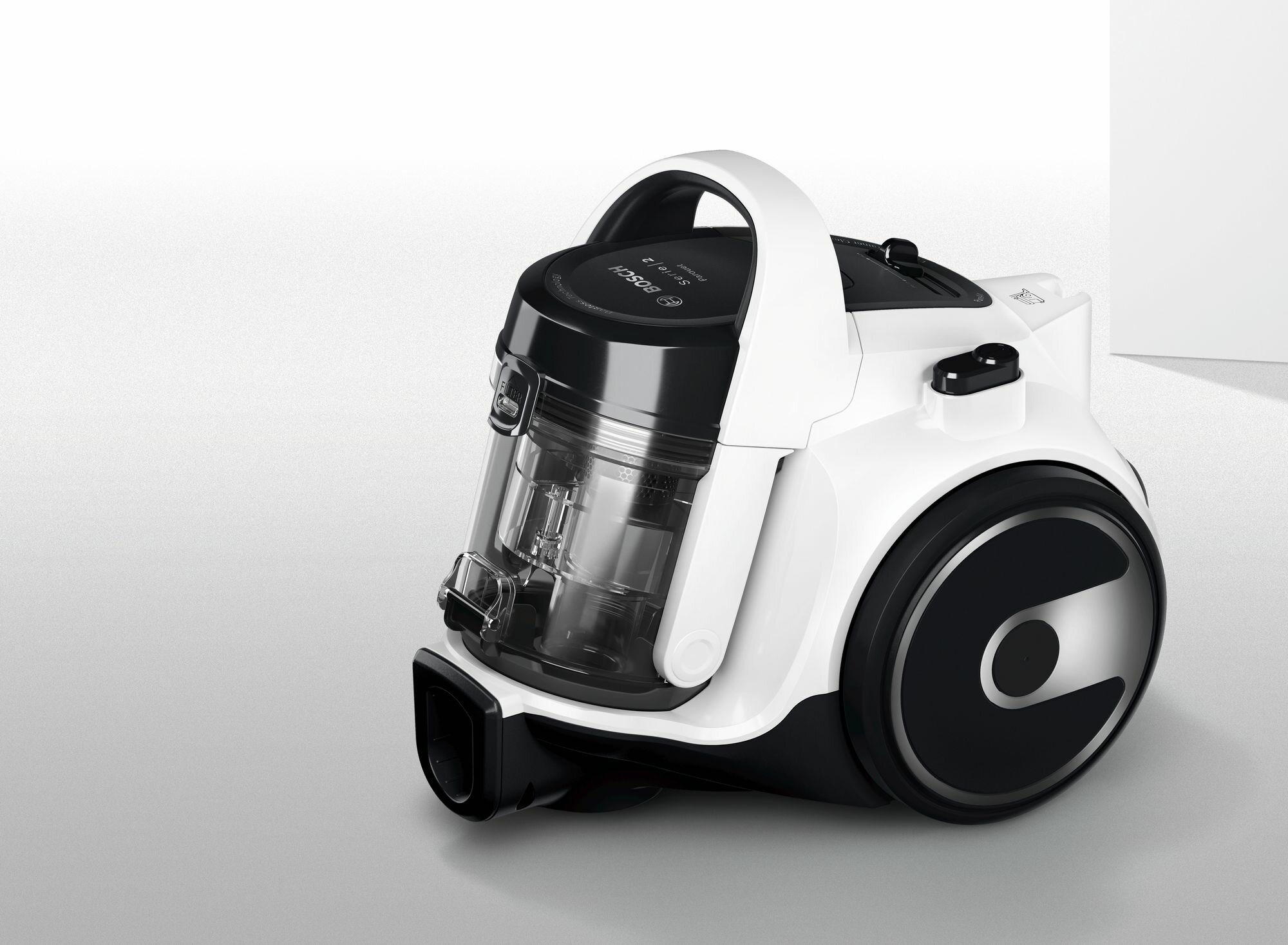 Biały odkurzacz z czarnymi akcentami, pokazujący pojemnik i uchwyt.