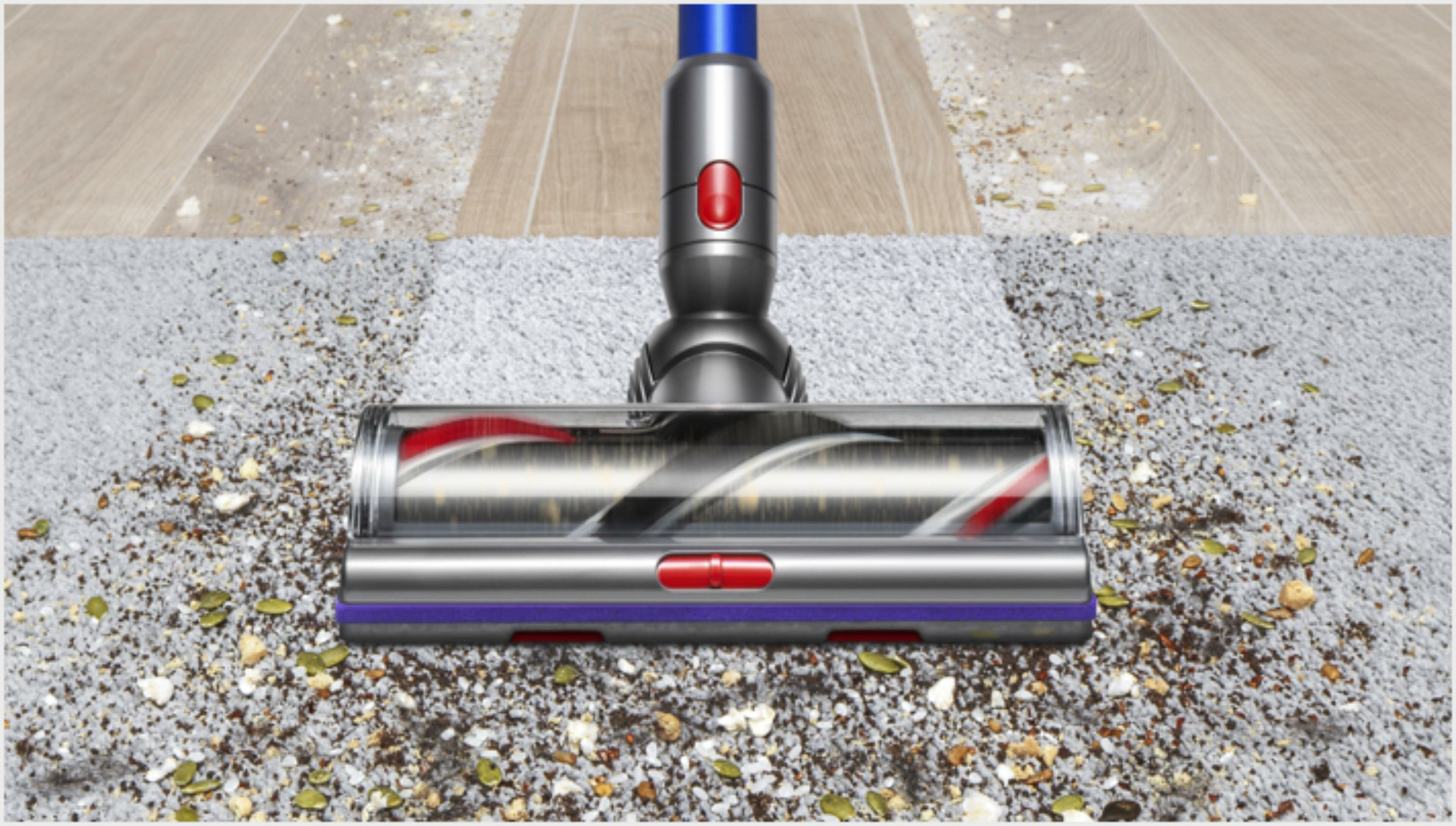 Głowica odkurzacza na dywanie. Dywan częściowo czysty. Widoczne zanieczyszczenia.