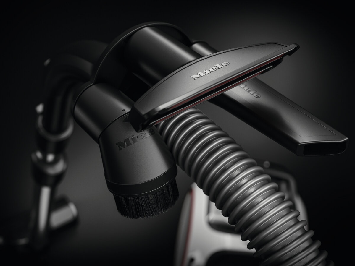 Czarne akcesoria do odkurzacza ze szczotką i dyszą na czarnym tle.