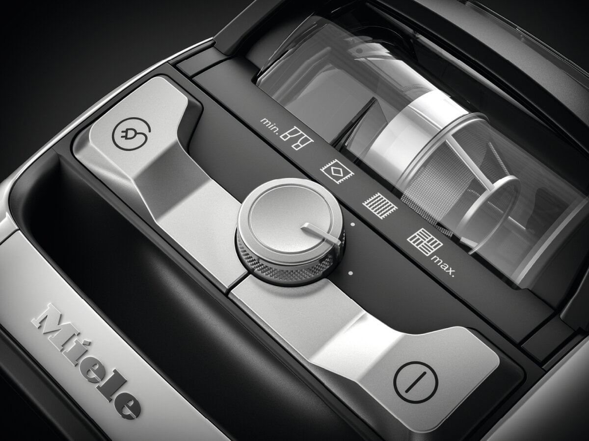 Zbliżenie panelu sterowania odkurzacza. Ma pokrętło obrotowe i przyciski.