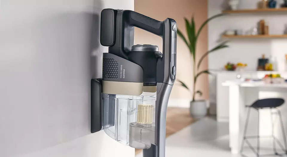 Odkurzacz bezprzewodowy wiszący na ścianie, pokazujący jego konstrukcję i części.