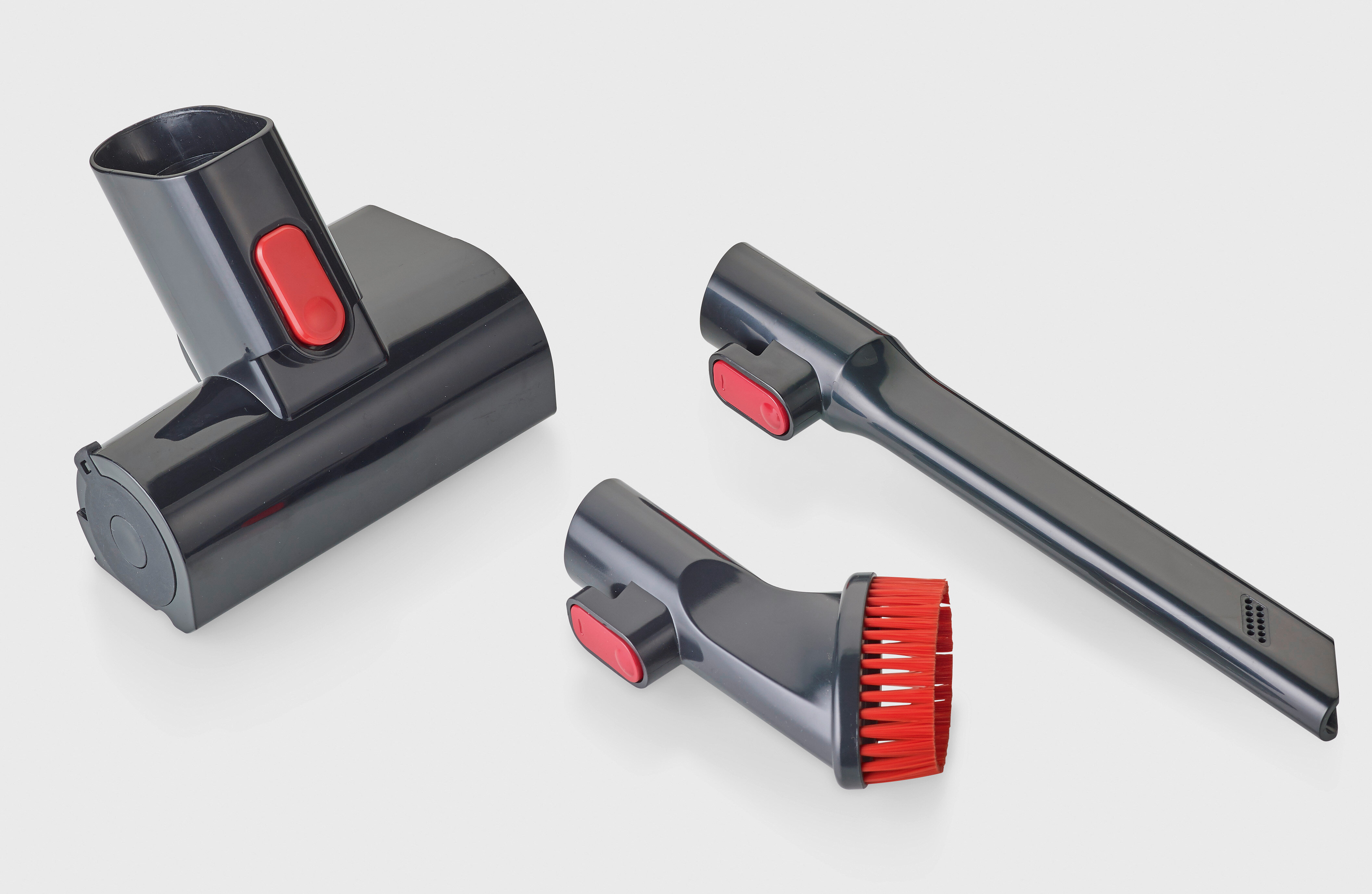 Akcesoria do odkurzacza: szczotka, głowica kątowa i długa dysza, wszystkie czarne z czerwonymi przyciskami, na białym tle.