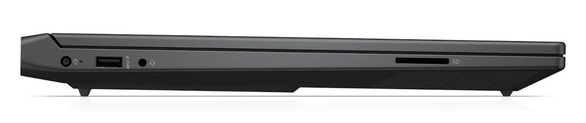 Widok z boku czarnego laptopa z portami i bocznym gniazdem kart SD, spoczywającego na białej powierzchni.