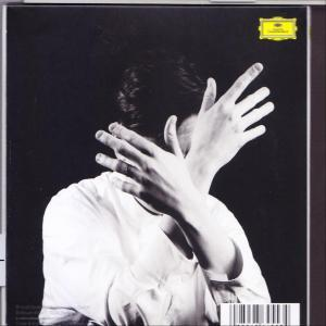 Albumcover mit Händen vor dem Gesicht einer Person vor schwarzem Hintergrund. Das Album ist in Graustufen gehalten.