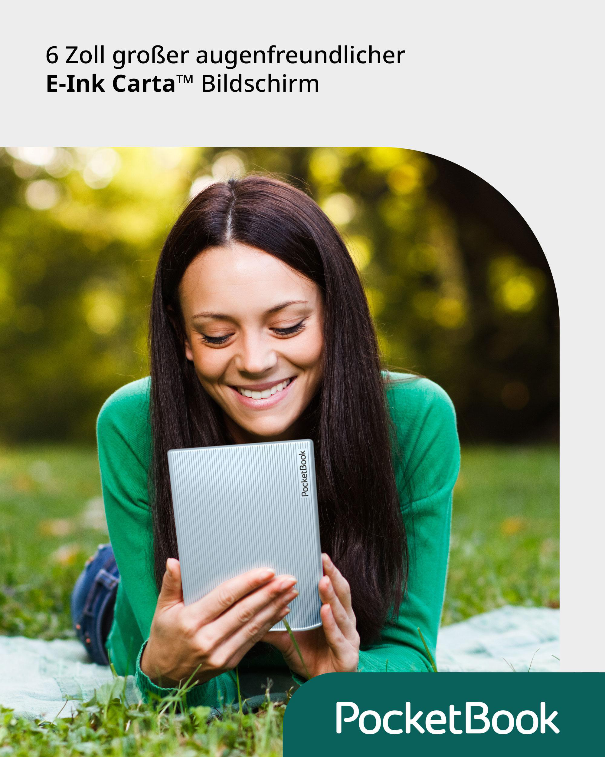Eine Frau lächelt und liest einen PocketBook E-Reader, während sie auf Gras in einem Park liegt.