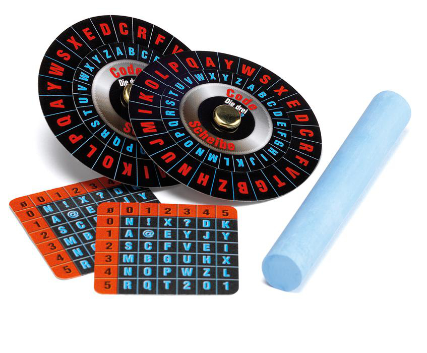 Code-Spiel mit zwei Code-Rädern, Karten und blauer Kreide auf weißer Oberfläche.