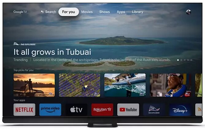 Telewizor Smart TV wyświetlający usługę strumieniowania z tropikalną wyspą i ikonami aplikacji na dole.