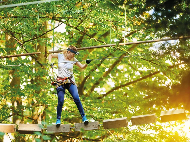 Eine Frau geht auf Holzplanken. Sie trägt einen Helm und einen Gurt, in einer Waldkulisse.
