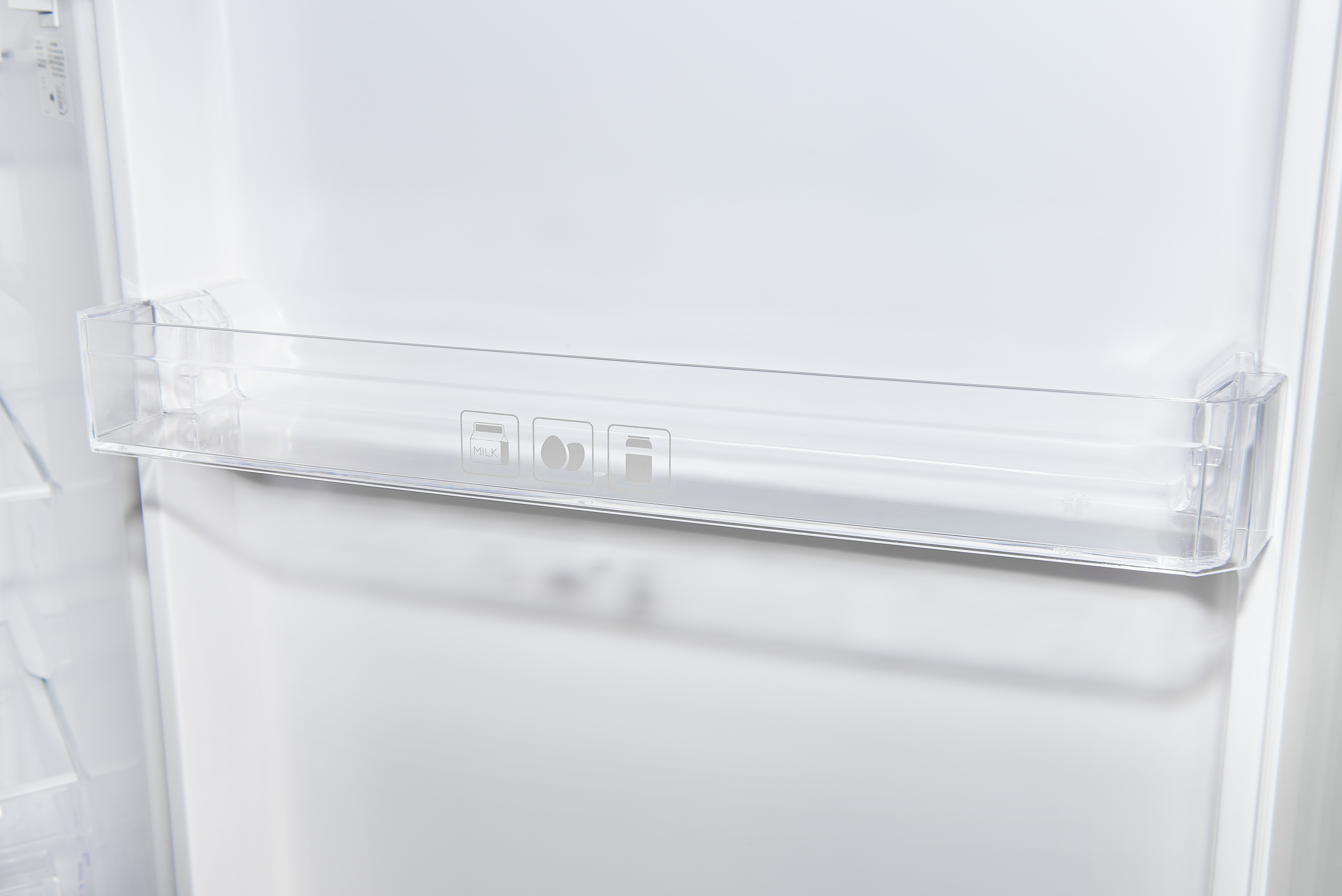 In einem weißen Kühlschrank ein durchsichtiges Regal mit Symbolen für Milch, Eier und Kanne.
