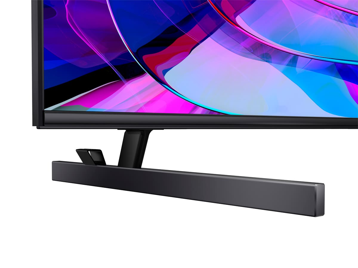 La parte inferior de un monitor de computadora negro. Un soporte negro y un fondo blanco.