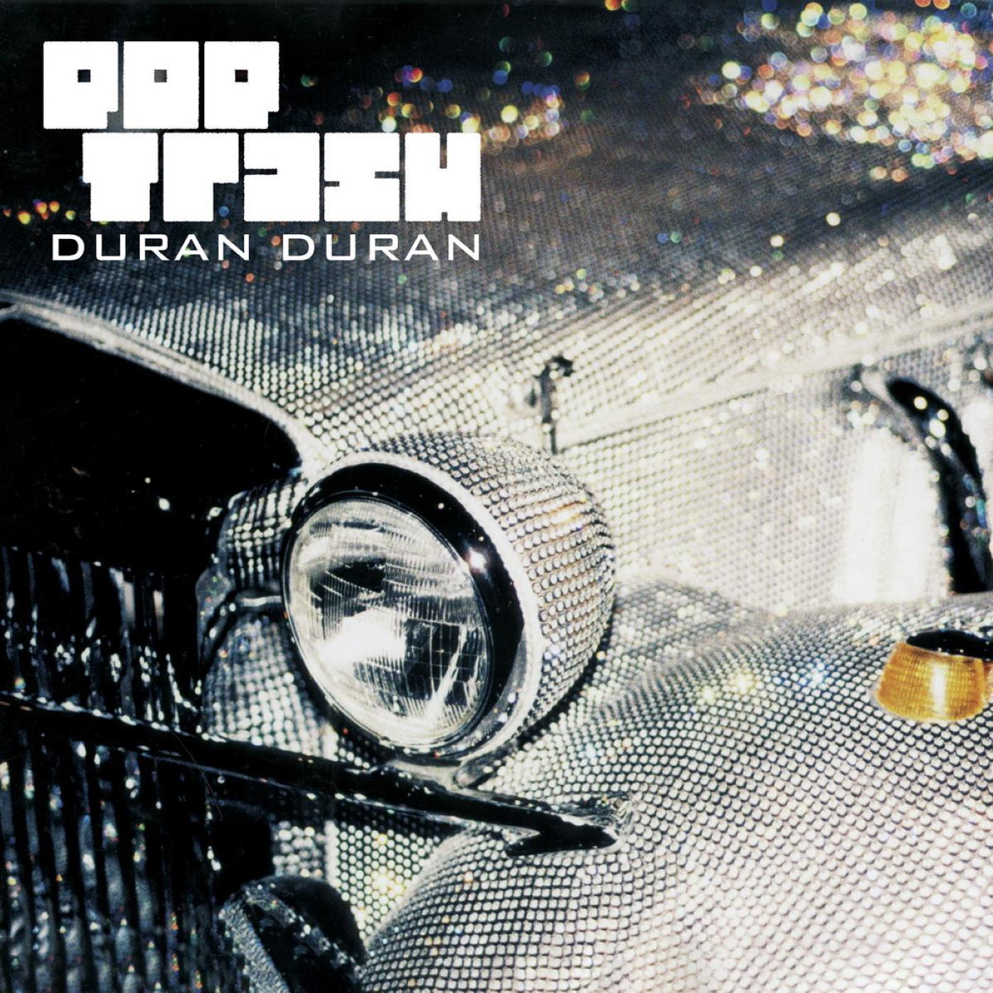 A Duran Duran Pop Trash album borítója. Egy strasszokkal borított autó eleje reflektorral.