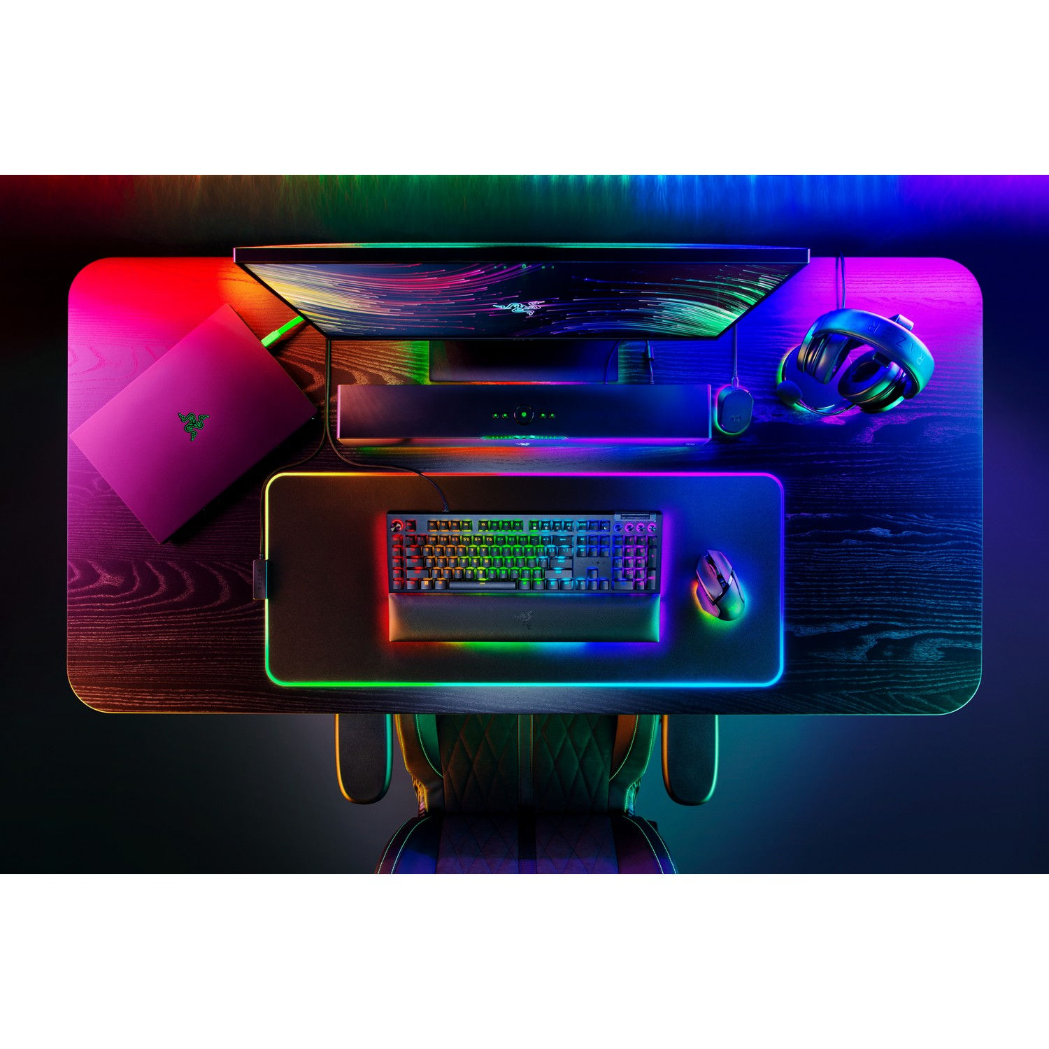 Top-down view of a gaming setup with neon lighting and a laptop.
