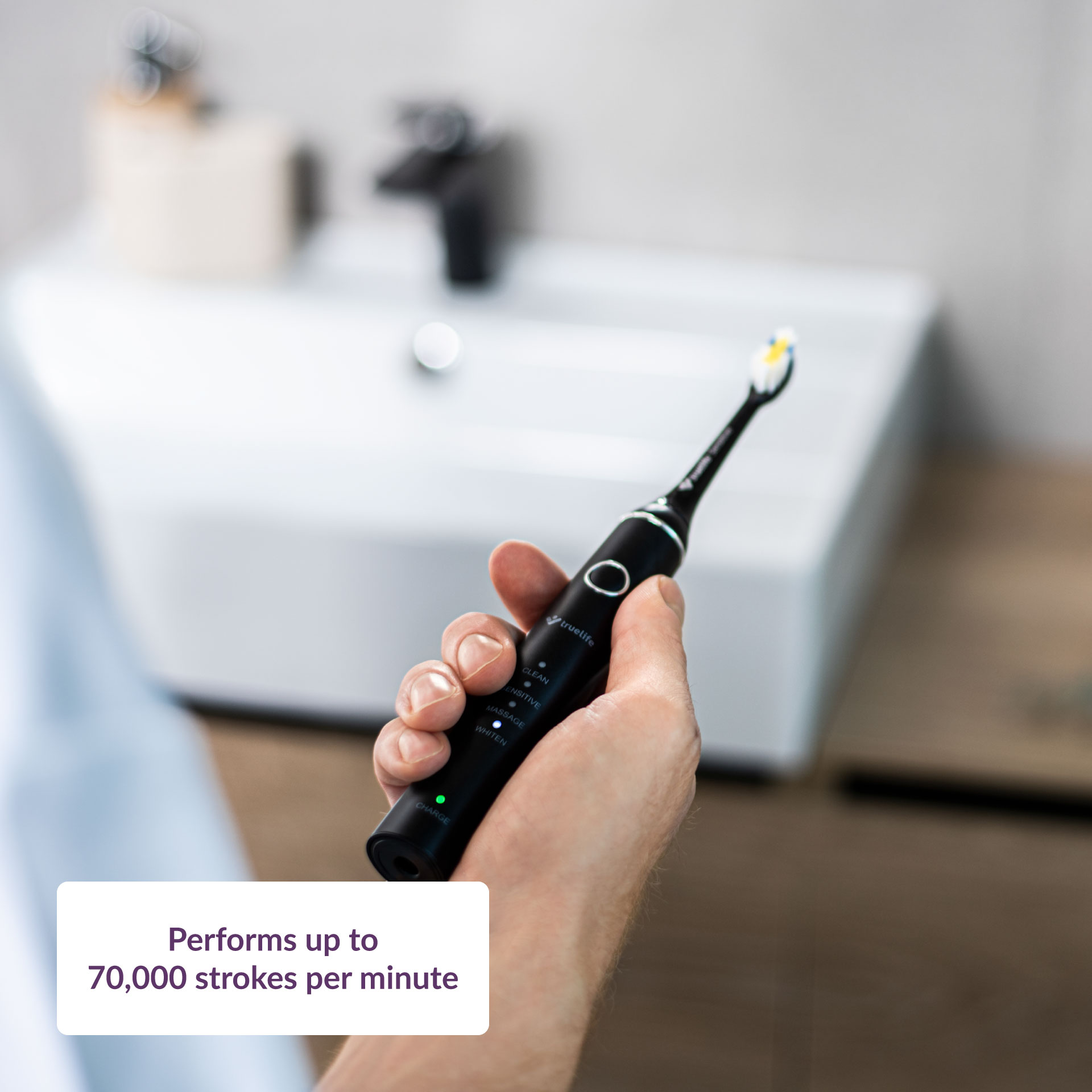 Kézben fekete elektromos fogkefe. Szöveg: akár 70 000 mozdulat percenként.
