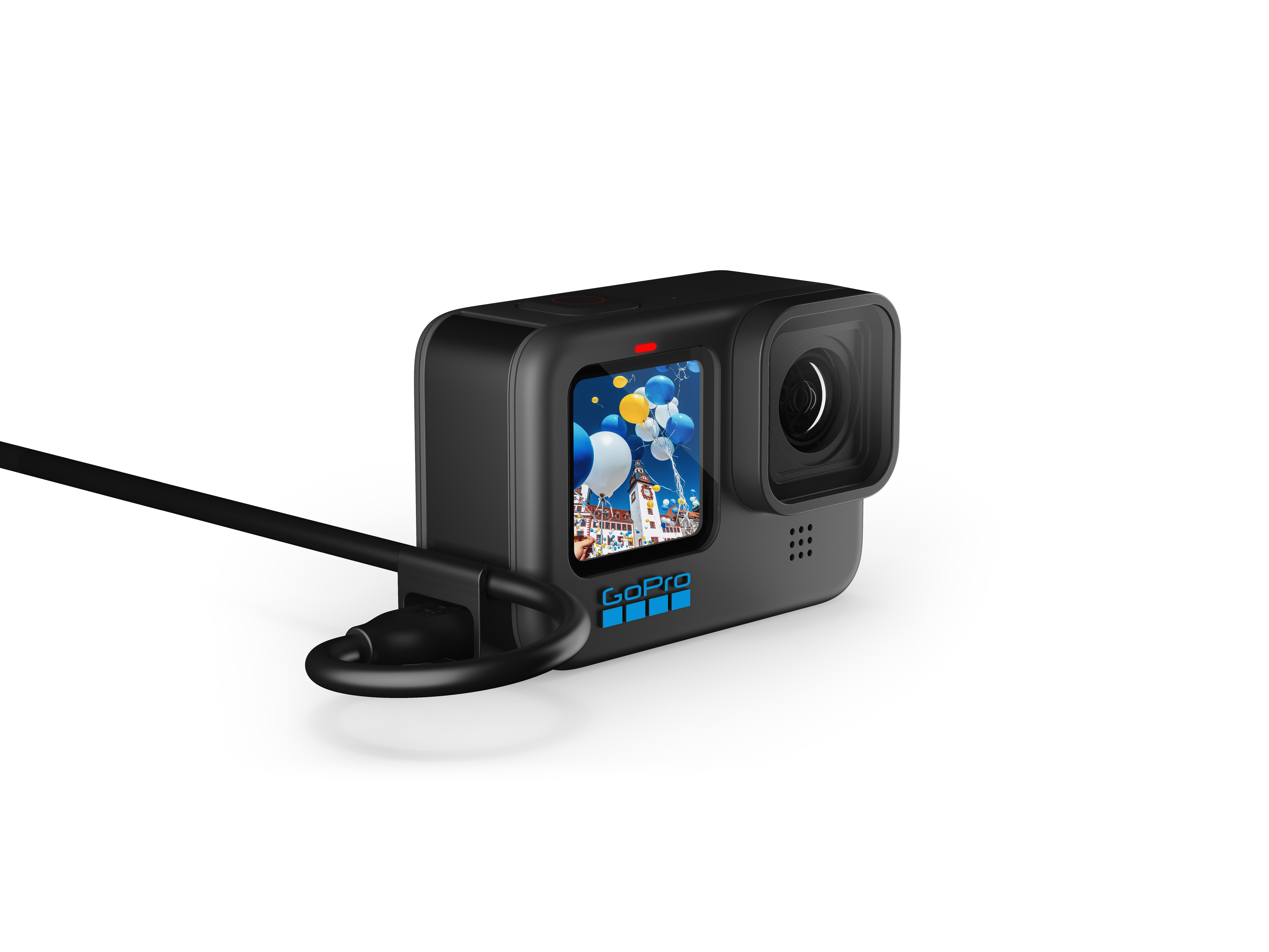 Schwarze GoPro-Kamera mit Bildschirm, der eine Karnevalsszene zeigt, verbunden mit Kabel.