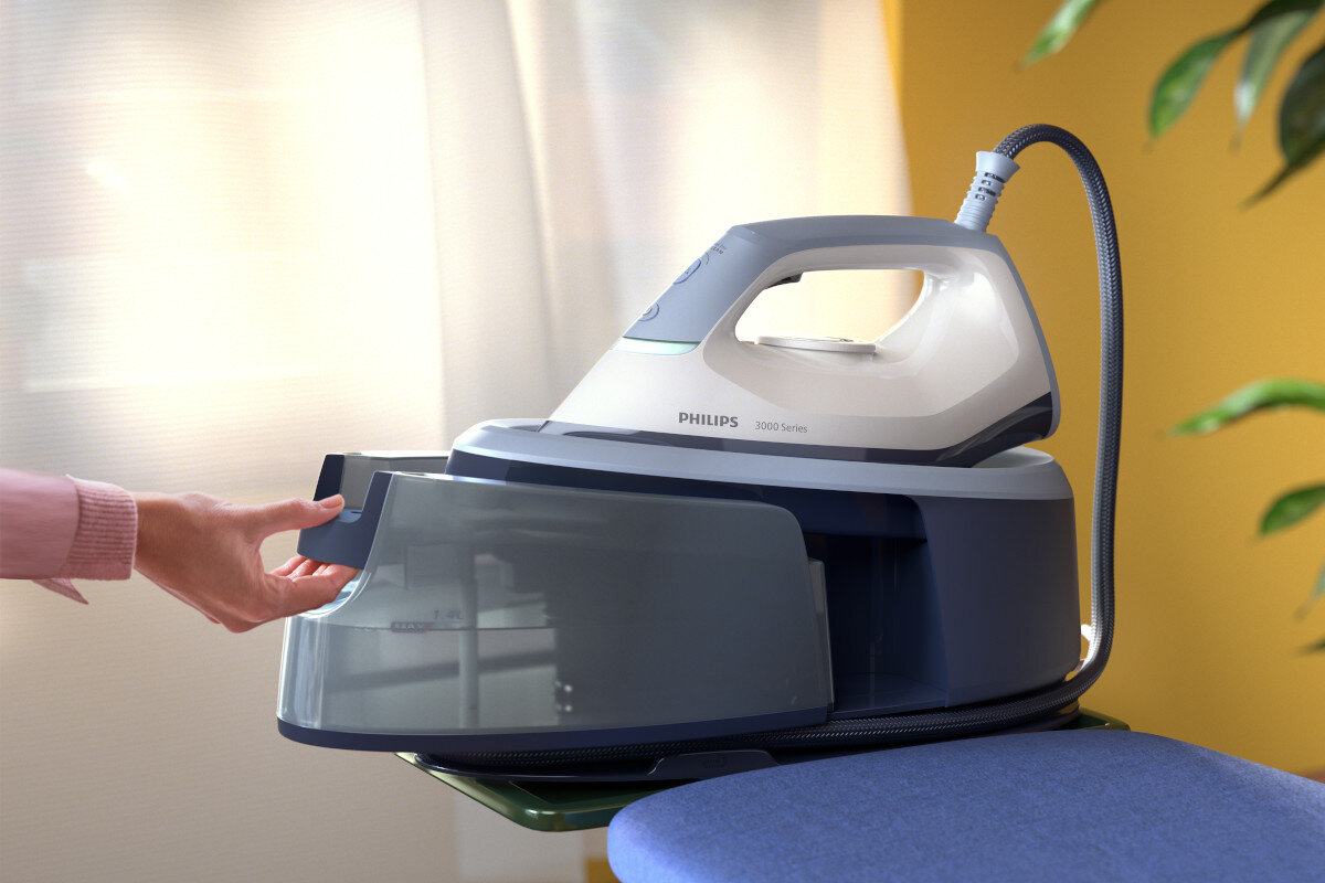 Ręka otwiera zbiornik na wodę białego i szarego żelazka parowego Philips.