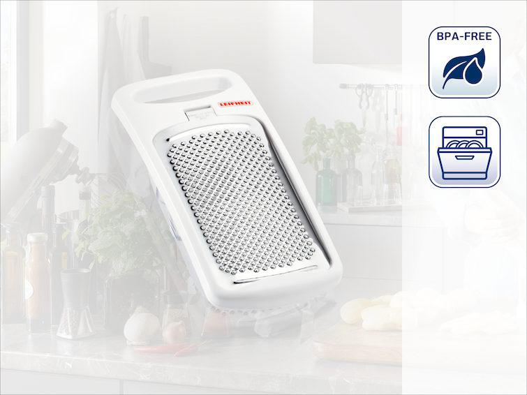Ein weißer Reibe mit Griff, mit BPA-frei und spülmaschinenfest Symbolen.