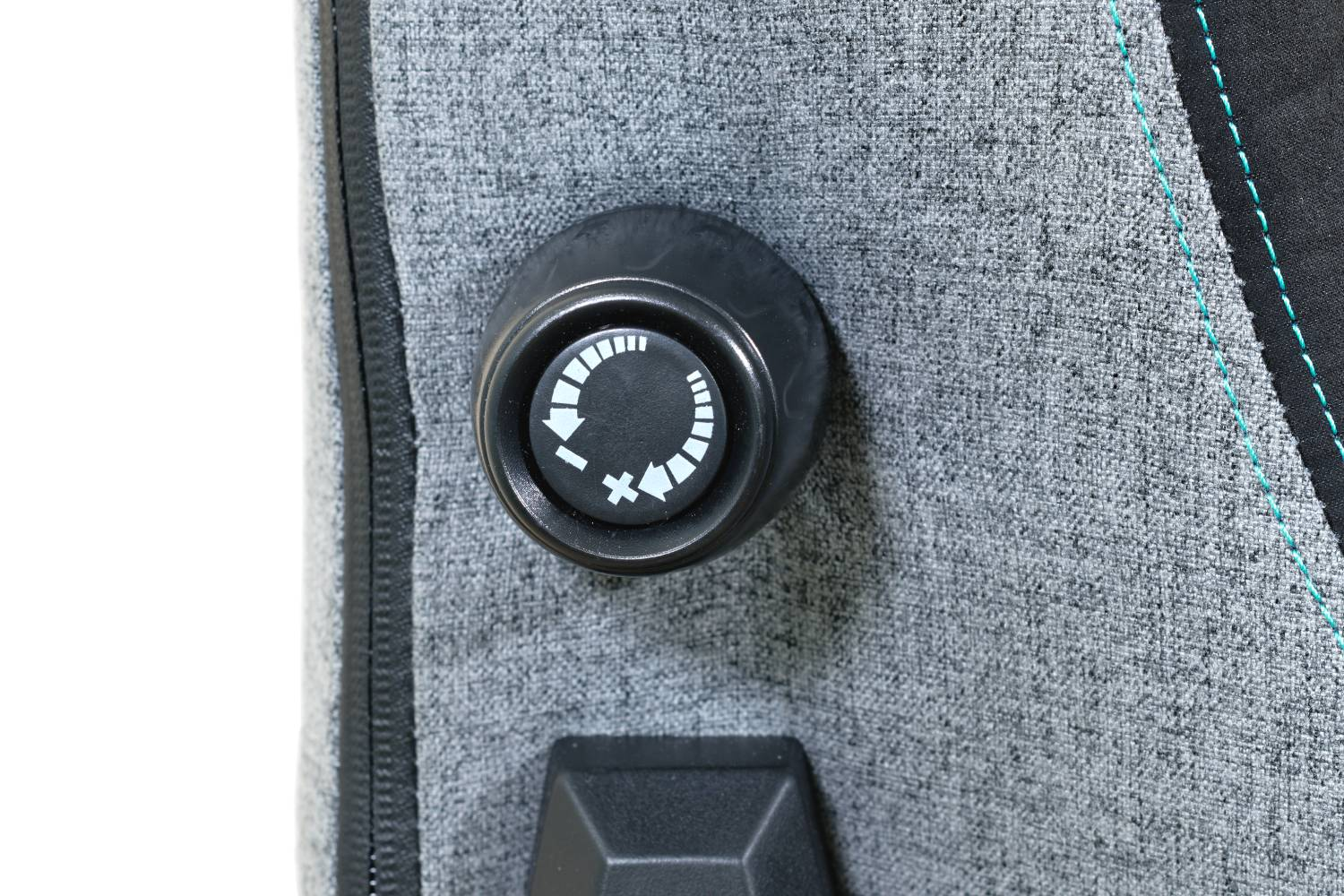 Primer plano de una tela gris con un dial negro que muestra flechas y números, un botón negro debajo.