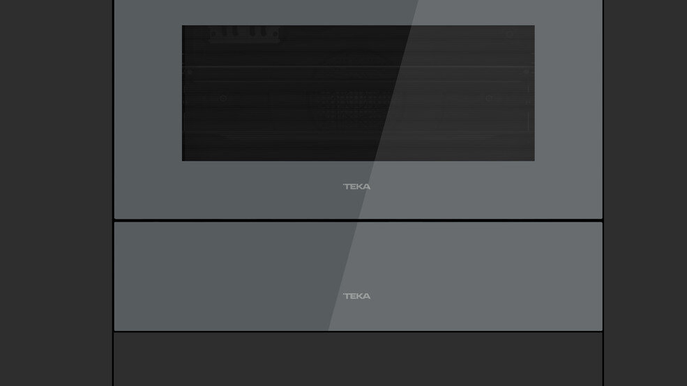 Wbudowany piekarnik TEKA. Jest ciemnoszary i ma szklane drzwi z napisem TEKA.