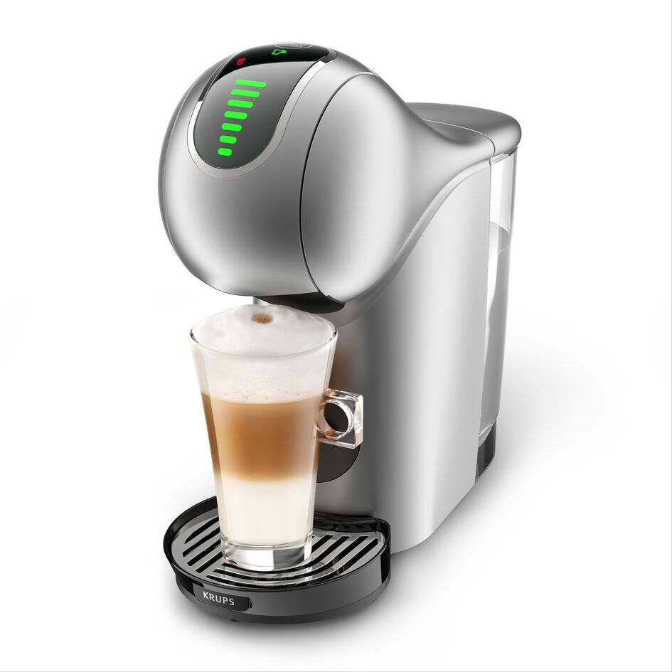 Ezüst kávéfőző egy pohár latte-val, egy kávéscsésze a kávéfőző alatt.