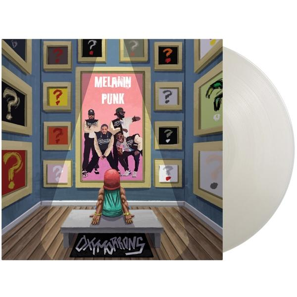 Vinyl lemez színes albumborítóval, amely egy kérdőjelekkel teli galériát ábrázol.