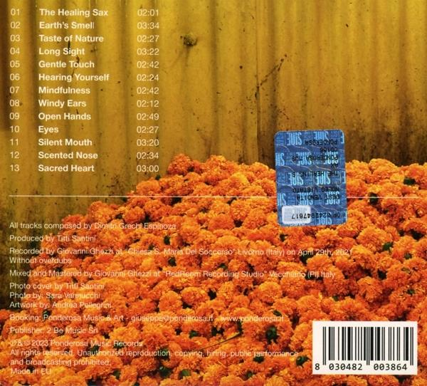 CD mit Text auf einem Bett aus orangefarbenen Blumen. Einige blau-weiße Aufkleber sind sichtbar.