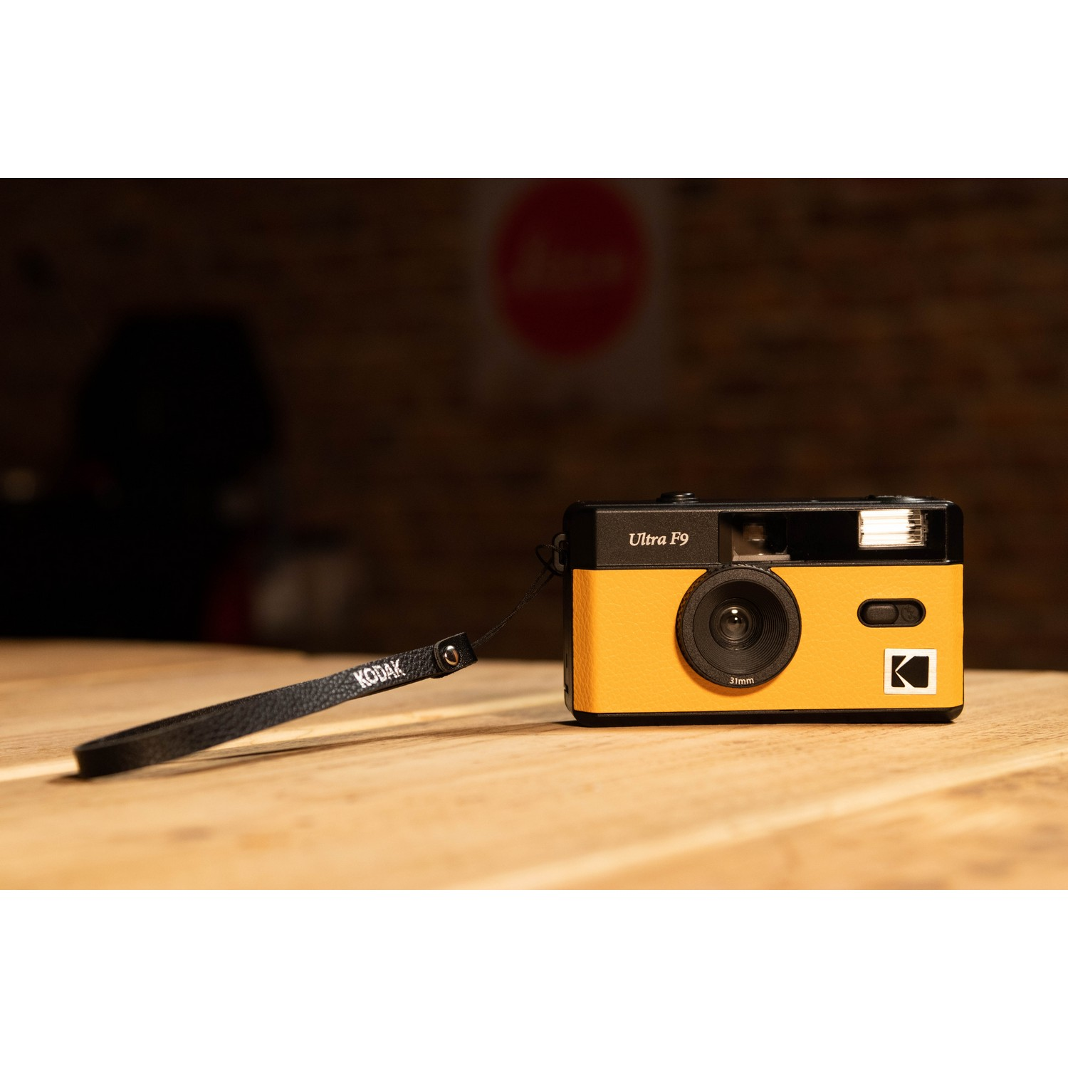 Kodak Ultra F9 camera, orange and black, on a wooden surface.