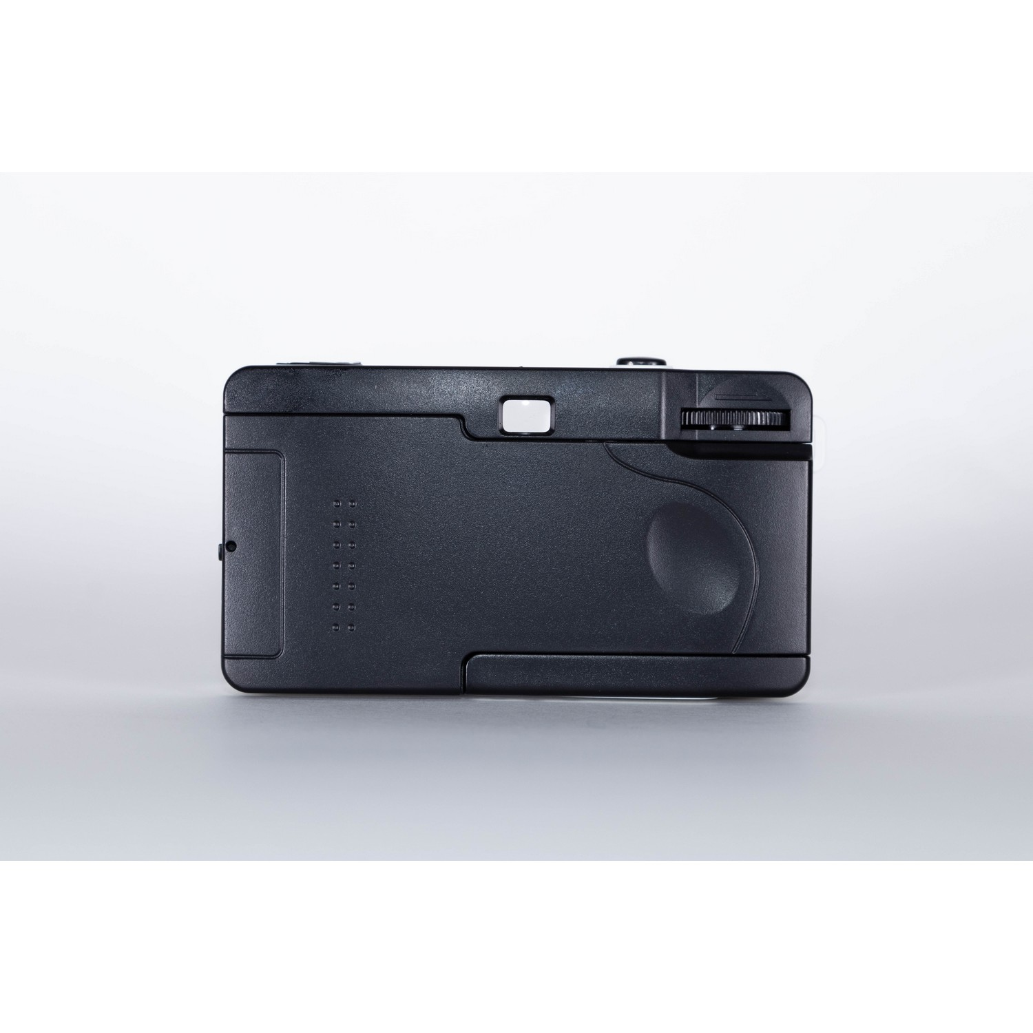 Black camera, top view. Buttons and dial visible. Gray background.