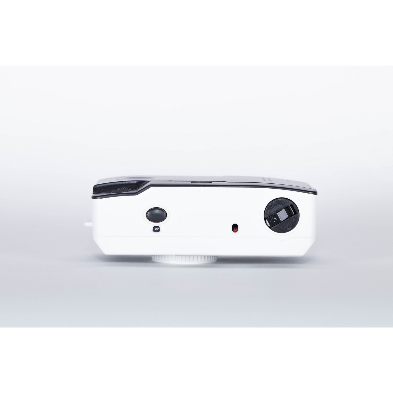 White camera, top view. It has a black button and a lens on the side.