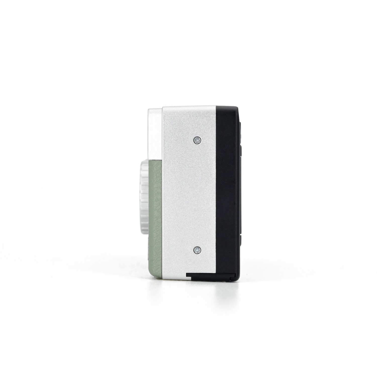 Side view of a camera with a silver and a black side. It has a green circle on the left side.