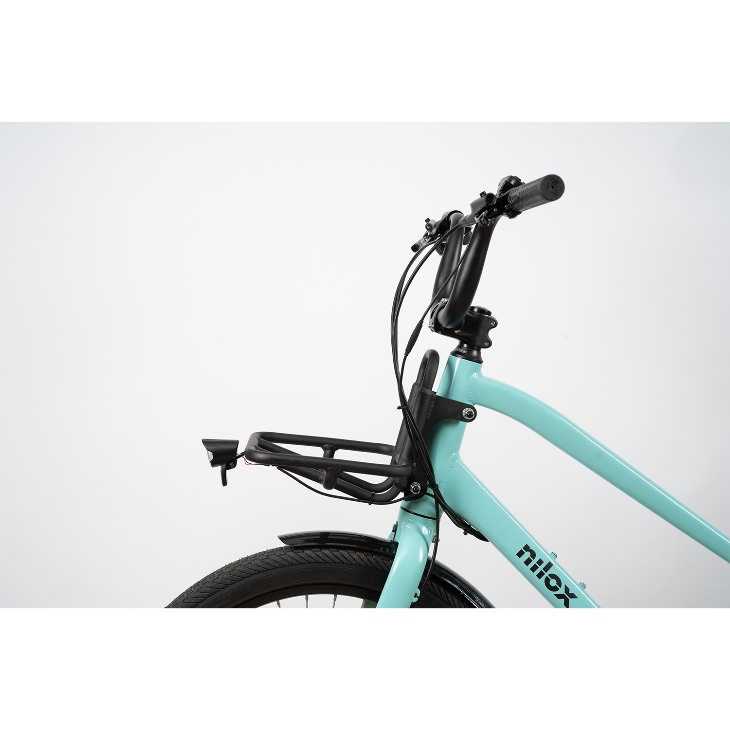 Bicicletta azzurra, dettagli neri. Focus sul manubrio e sul cestino anteriore. Sfondo bianco.