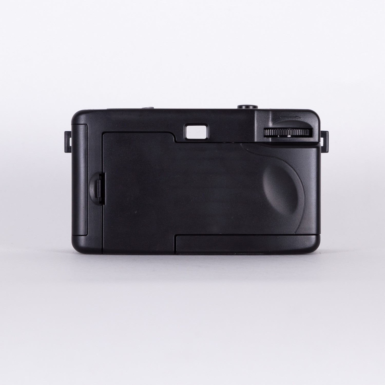 A black camera back, with a small viewfinder and a dial. It's on a white background.