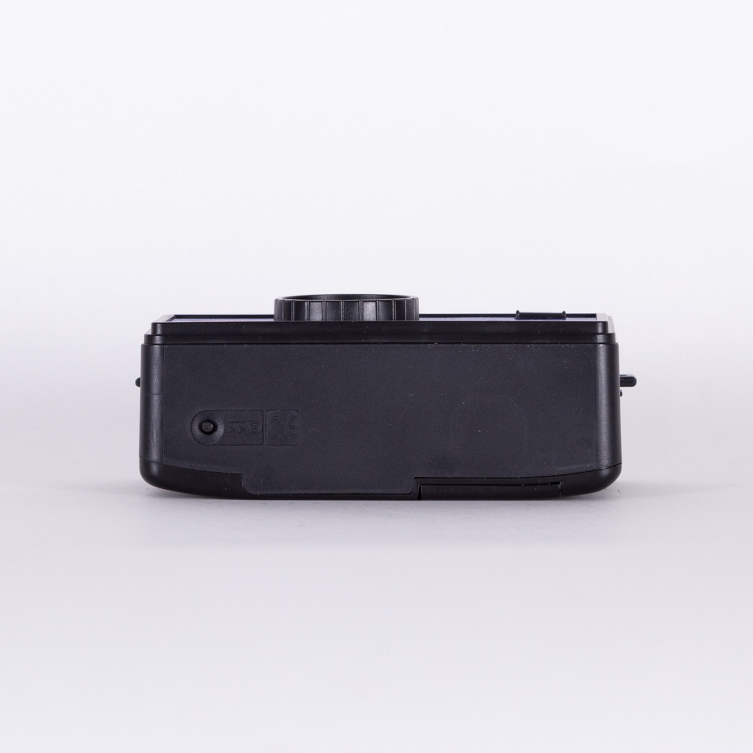 Black camera on white background, showing top with dials.