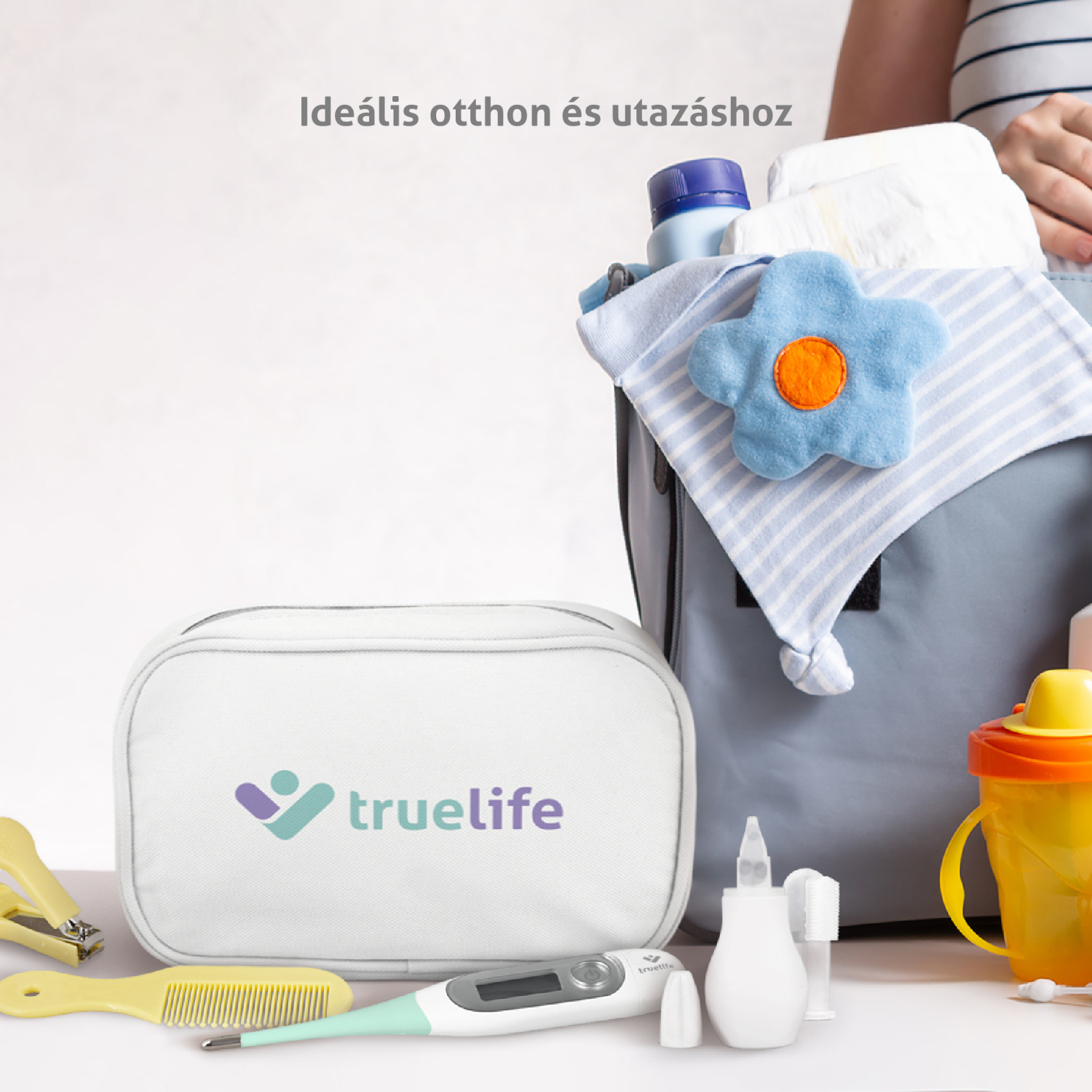 Egy fehér TrueLife táska babaholmikkel egy fehér felületen.