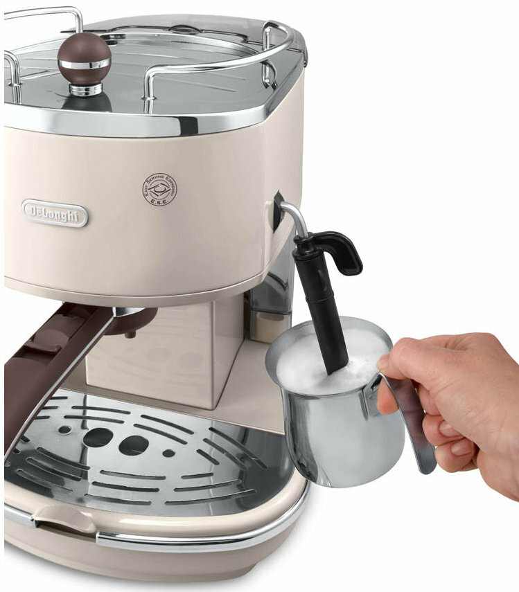 Kremowy ekspres do kawy ze srebrnym uchwytem i ręką spieniającą mleko w srebrnym dzbanku.