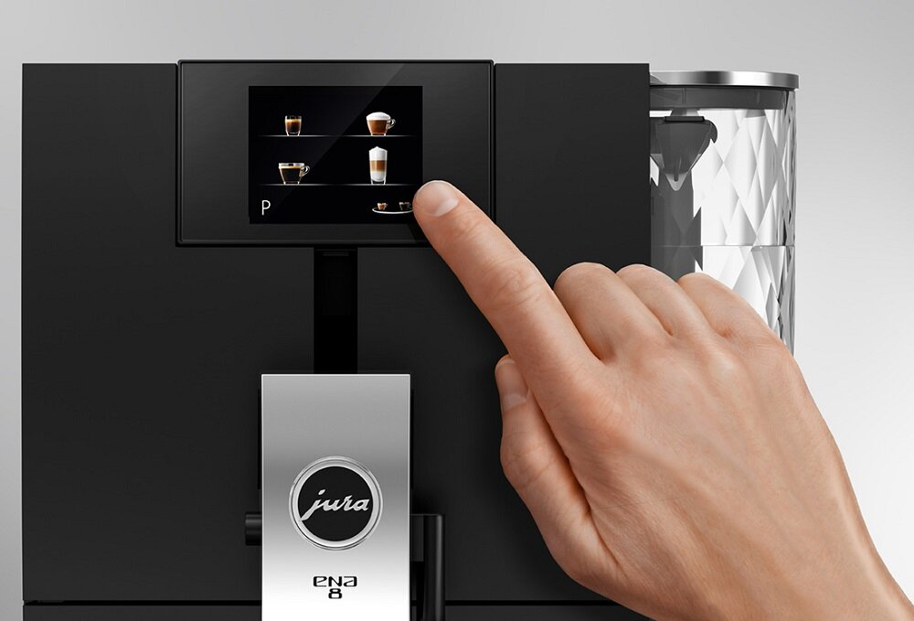 Dłoń dotyka ekranu ekspresu do kawy. Ekran wyświetla opcje napojów kawowych.