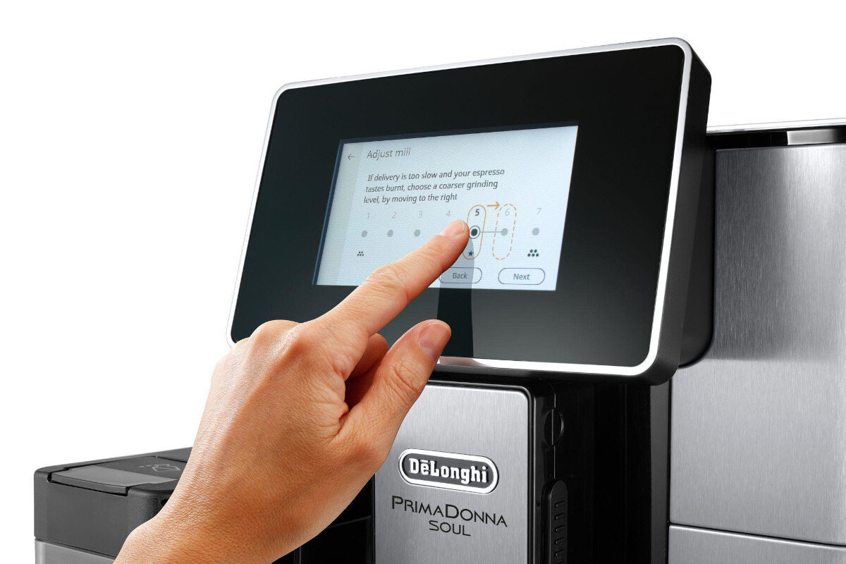 Ręka osoby dotykająca ekranu dotykowego ekspresu do kawy.