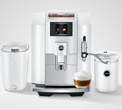 Biały ekspres do kawy z pojemnikami. Widoczna filiżanka kawy z pianką. Białe tło.