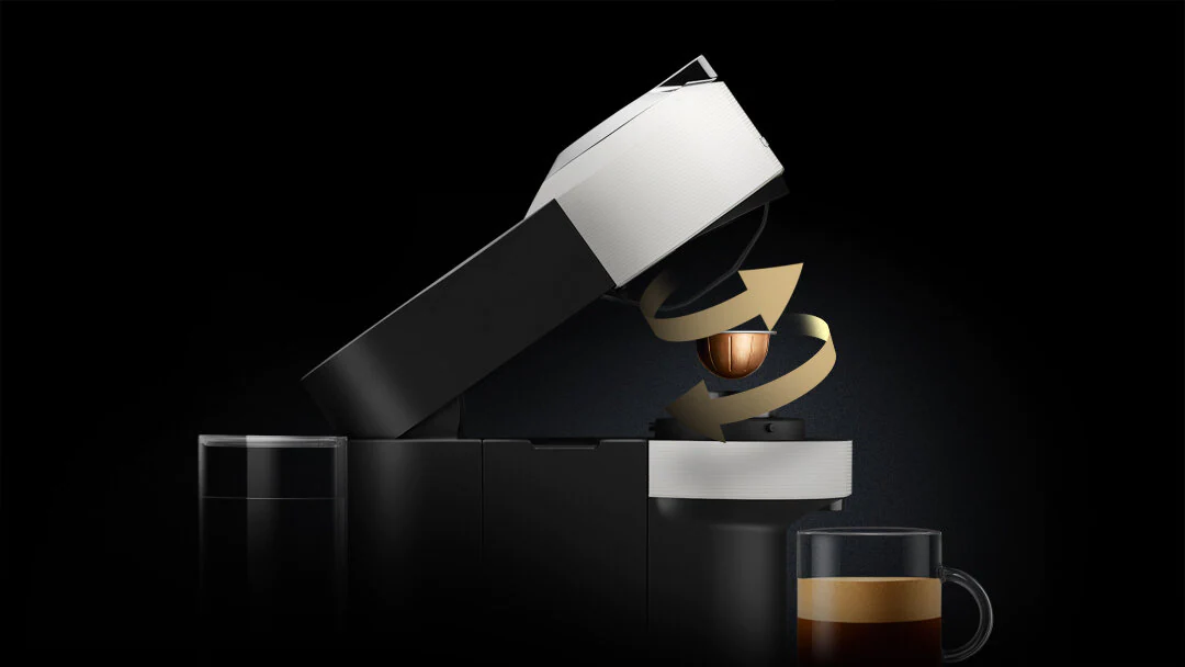 Czarny i srebrny ekspres do kawy z wkładaną kapsułką.