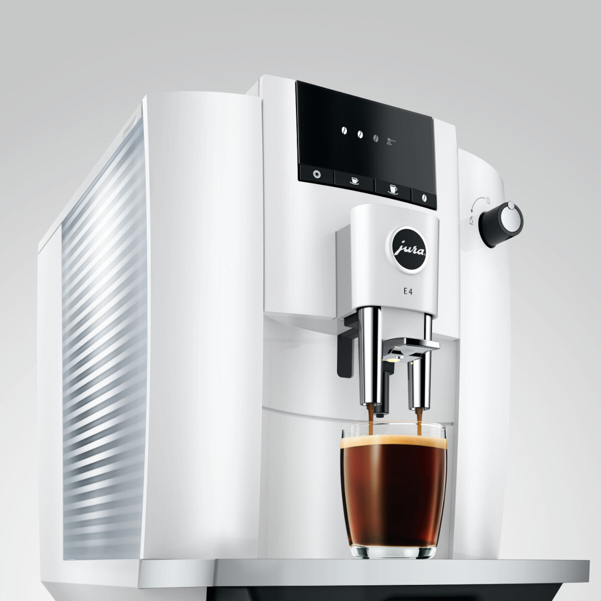 Biały ekspres do kawy Jura E4 ze szklanką kawy. Kawa wlewa się do szklanki.