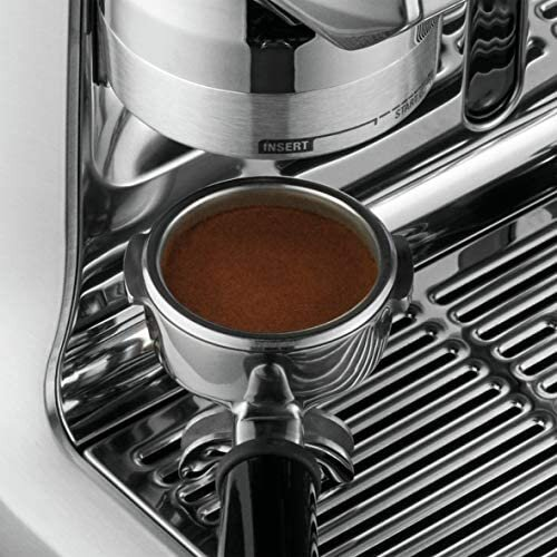 Zbliżenie portafiltra wypełnionego zmieloną kawą w ekspresie do espresso ze stali nierdzewnej.