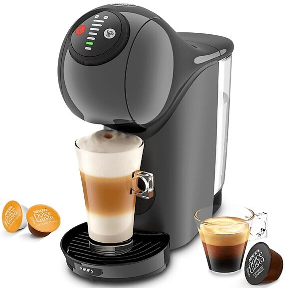 Czarny ekspres do kawy Krups Dolce Gusto. Szklanka z latte i kapsułkami. Czarna podstawa i szklanka z kawą.