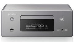 Srebrny odtwarzacz CD Denon. Ekran wyświetla informacje o muzyce.